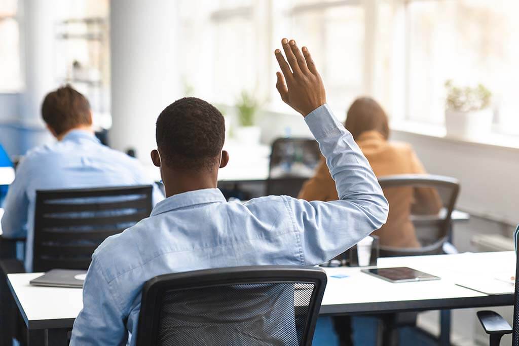 Student raising their hand in class