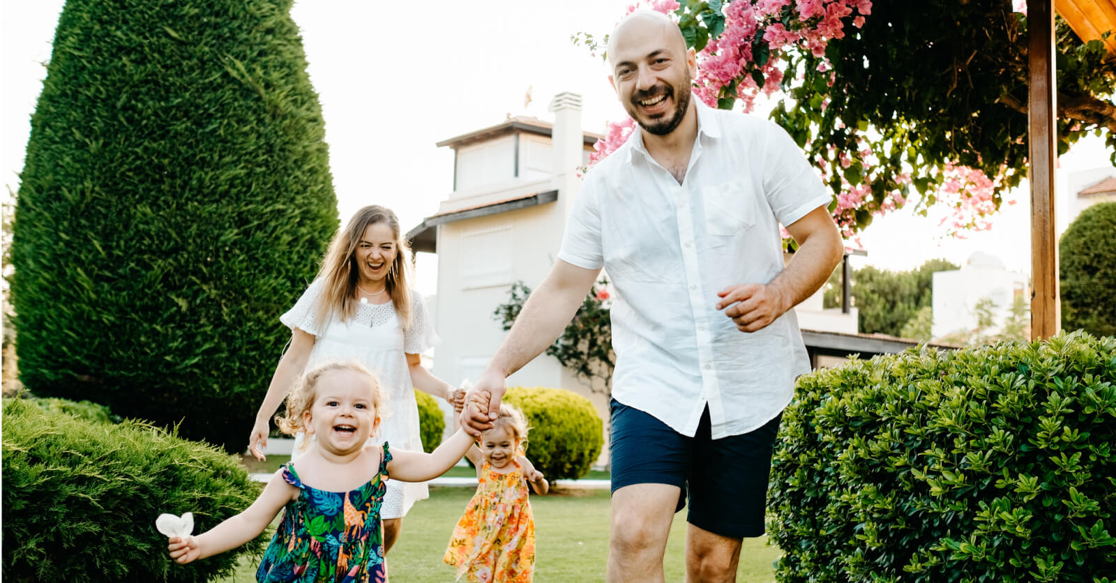 Family smiling in front of home