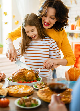 Mom helping child carve turkey