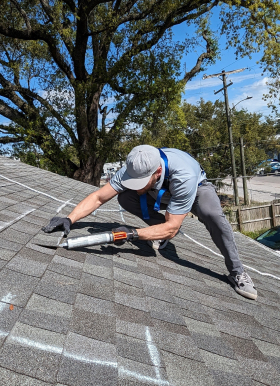 Man resealing roof shingles