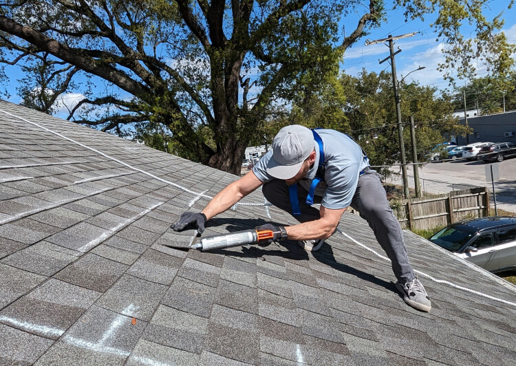 Man resealing roof shingles