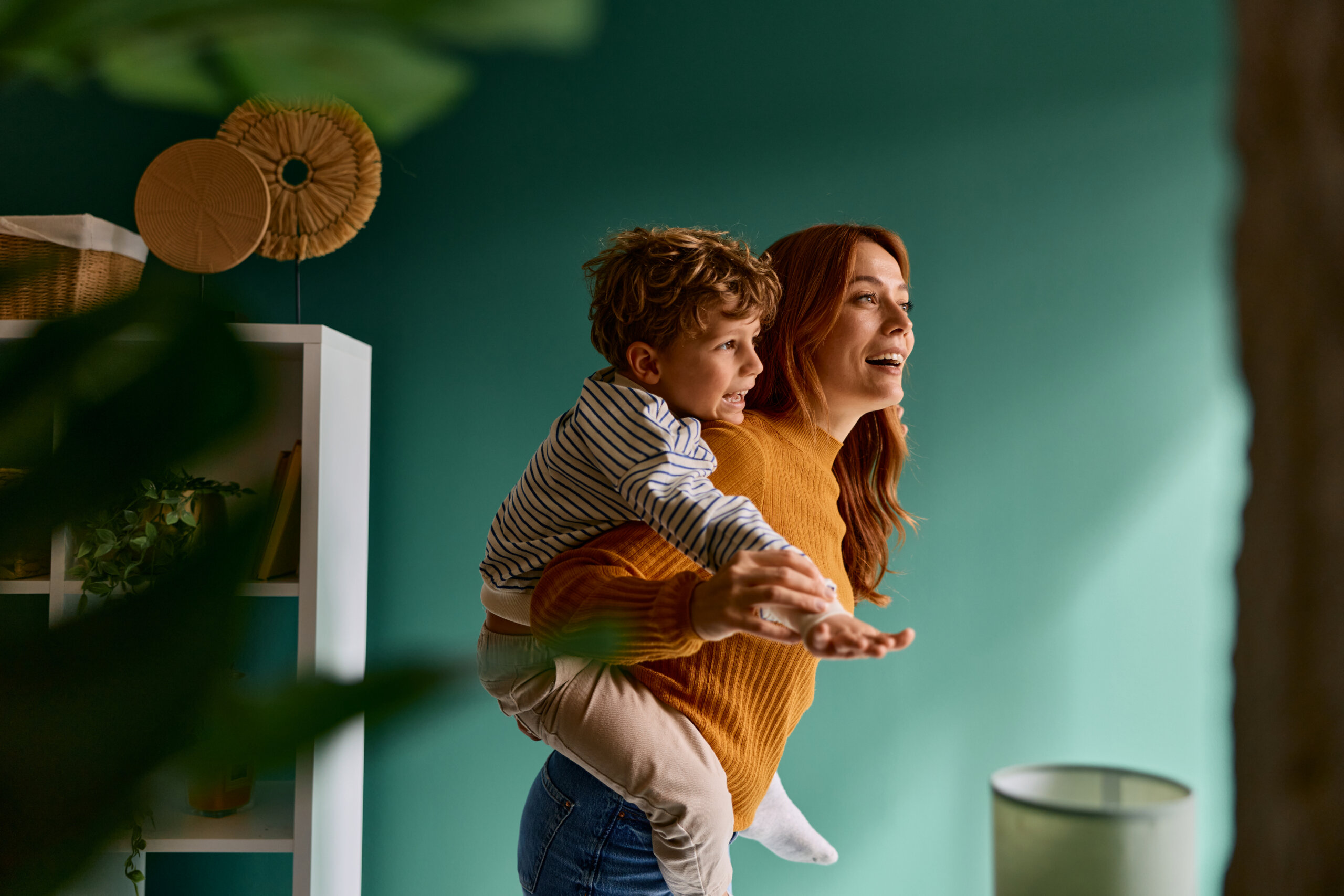 Mother giving son piggyback ride at home